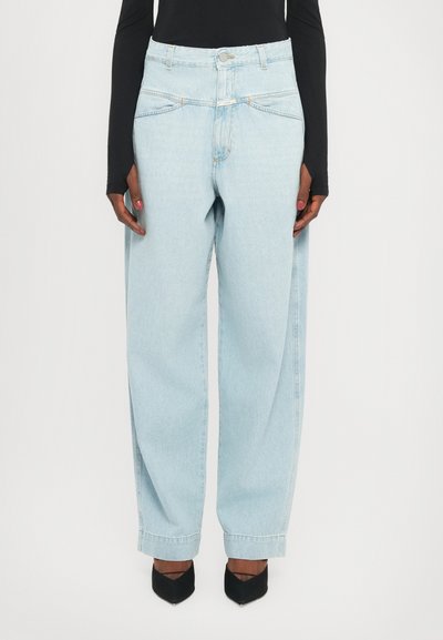 Lichtblauwe high-waisted jeans met een losse fit, voorzien van voorzakken, lichte stiksels en een knoopsluiting. Draag ze met zwarte hakken.