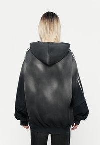 Black and gray gradient hoodie with a hood, oversized fit, and white side stripes. Soft fabric with a smooth texture and elastic waistband.
