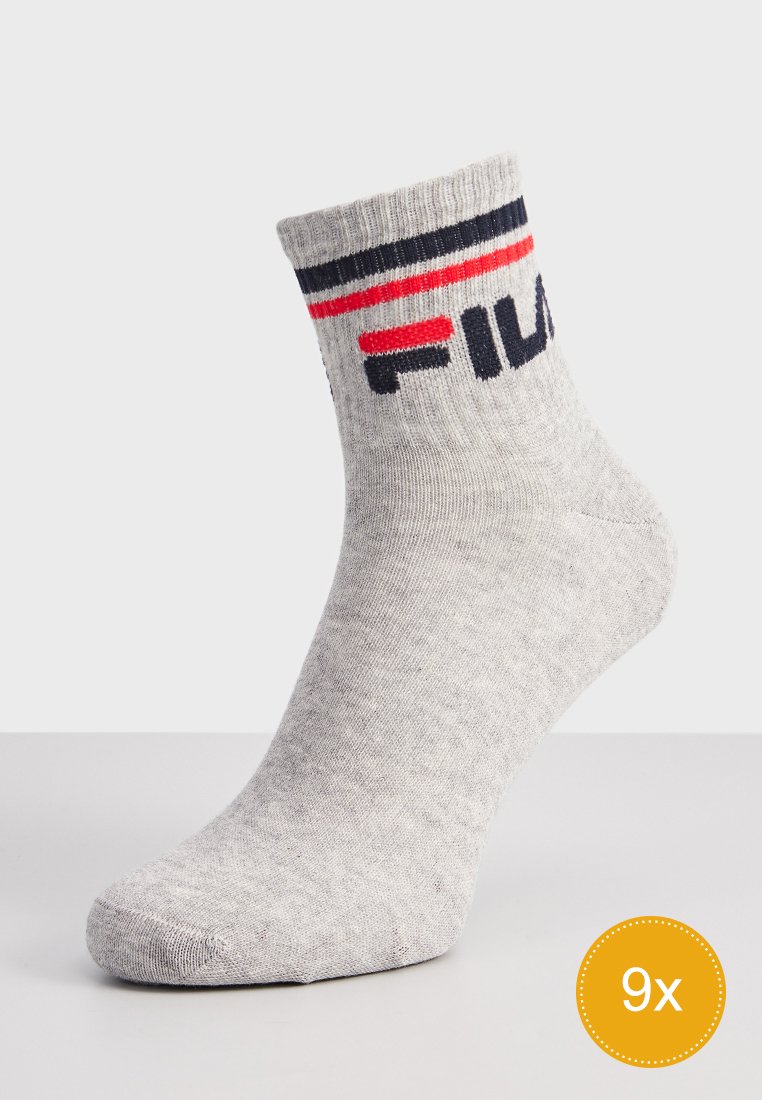 Szara skarpetka do kostek z mieszanki bawełny, z prążkowanym ściągaczem w niebiesko-czerwone paski oraz czarnym logo "FILA" z boku.