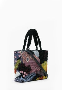 Rektangulær taske med teksturerede sorte håndtag, tværgående rem og flerfarvet abstrakt perle- og trådbroderi på stoffets overflade.