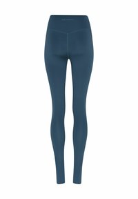 Donkergroene, hooggetailleerde legging tot op de enkels met zichtbare naden en "GIRLFRIEND" bedrukt op de achterkant van de tailleband.