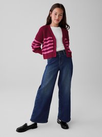 Cardigan a maglione bordeaux con strisce rosa, t-shirt bianca, jeans in denim blu a gamba larga e mocassini neri con calzini bianchi.