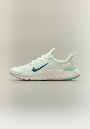 Chaussure de sport vert clair et blanche avec un logo Swoosh vert foncé, tige en mesh respirant et semelle épaisse amortie, présentée de profil sur un fond uni.