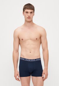 Tengerészkék pamut boxer alsónadrág, testhezálló kialakítással és elasztikus derékrésszel, amelyen ismétlődő "PIER ONE" felirat található. Sima felület, combközép hosszúság.