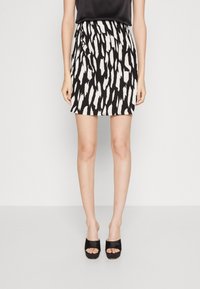 Svart och vit mönstrad kjol med utfälld design, tillverkad av lättviktigt tyg, med en slät yta och en figurnära midja.