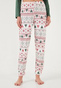 Pantaloni de pijama dintr-un amestec de bumbac, cu un model de Crăciun care include culori roșii, verzi și albe, inclusiv brazi și fulgi de zăpadă.