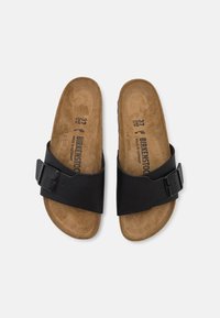 Sandali in pelle nera con sottofondo in sughero marrone, caratterizzati da una fascia larga con fibbia in metallo. Suola piatta, design con punta aperta. Taglia 37.