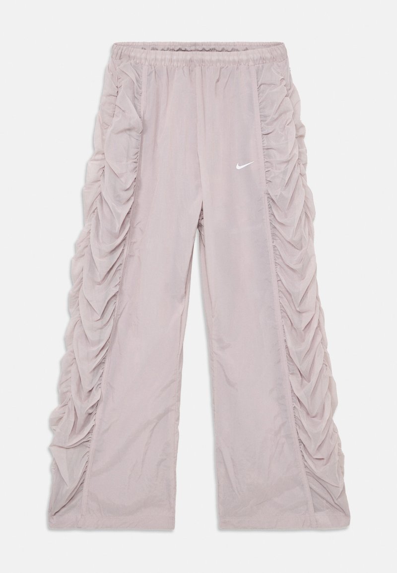 Pantalon Nike rose clair avec une texture froncée sur les côtés ; taille élastique et logo en haut à gauche.