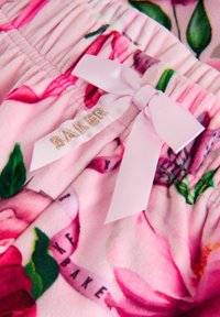Rosa Blumen-Pyjama-Shorts aus weichem Stoff, mit einem gerafften Taillenbund, einer Satinschleife und dem Text "BAKER" in goldener Stickerei.