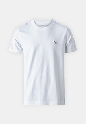 T-shirt en coton blanc avec un col rond. Présente un petit logo en bleu marine d'un élan sur la poitrine gauche. Texture douce, coupe régulière, manches courtes.