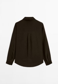 Mörkbrun långärmad skjorta med krage, detalj med klyfta bak och knäppte ärmslut. Materialet verkar slätt med en något strukturerad design.