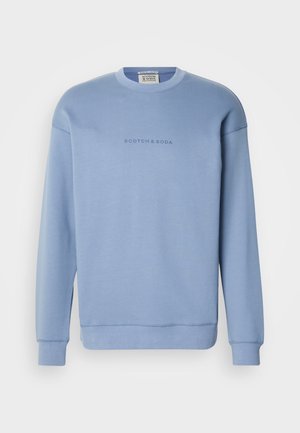 Light blue crewneck sweatshirt made of soft fabric, featuring the text "SCOTCH & SODA" in a subtle font on the chest. Long sleeves, ribbed cuffs.