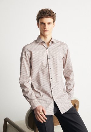 Camicia chiara con colletto classico in un motivo geometrico, realizzata in un tessuto testurizzato, con bottoni scuri.