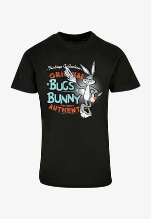 Schwarzes T-Shirt mit Bugs Bunny im Vintage-Stil, der eine Karotte hält und ein Friedenszeichen macht. Der Text lautet: "Original Bugs Bunny und immer authentisch."
