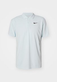 Jasnoniebieska koszulka polo wykonana z gładkiej tkaniny. Posiada klasyczny kołnierzyk, krótkie rękawy oraz małe czarne logo Nike na lewej piersi.