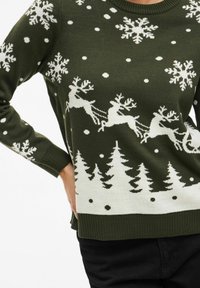 Green knitted sweater featuring white reindeer, snowflakes, and trees in a winter scene pattern. Ribbed neckline and hem details.