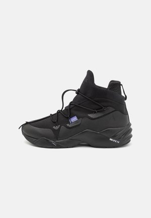 Zwarte hoge sneaker met dikke, getextureerde zool, unieke zijvetering, mesh- en lederen panelen, en een klein paars labeltje bij de veters.