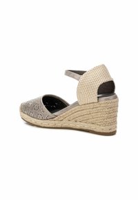 Sandalía cuña de color gris claro con parte superior de ante perforado, tacón trenzado beige, correa de tobillo y detalles de cuerda estilo esparto texturizada.