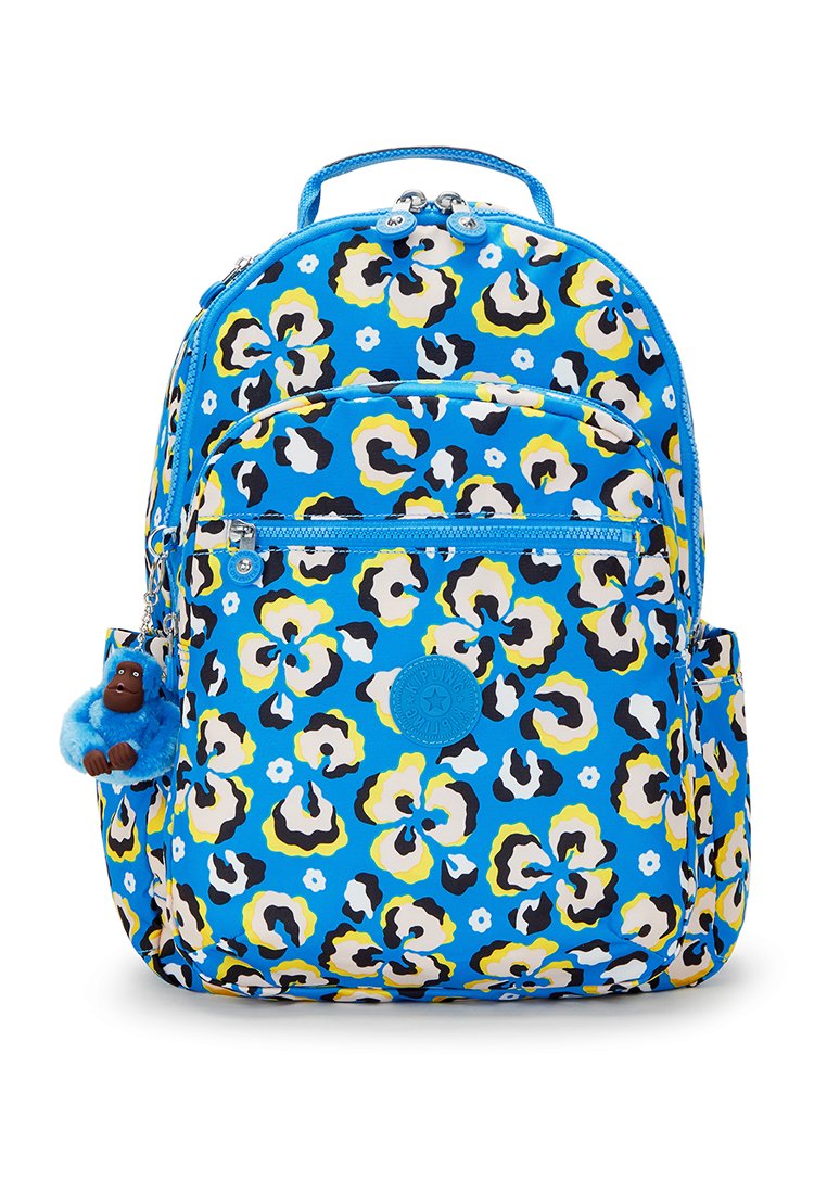 Sac à dos bleu avec un imprimé léopard floral en blanc, jaune et noir. Comprend des poches zippées et un porte-clés poilu bleu en accent.