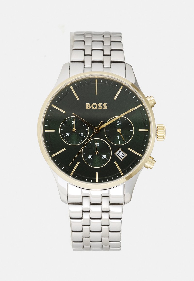 Reloj cronógrafo con un dial negro, acentos dorados, pulsera de metal plateado, tres sub-diales y una pantalla de fecha a las 6 en punto.