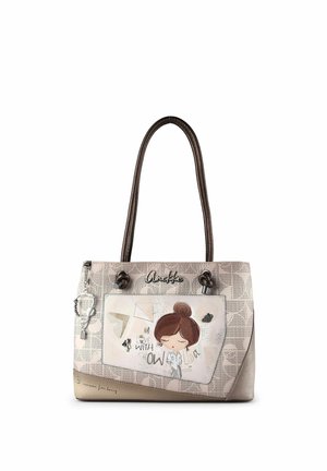 Beigefarbene Handtasche mit braunen Griffen, Fronttasche mit einer Illustration eines Mädchens und dem Text "Verliebt in Wissen" mit dekorativen Anhängern.