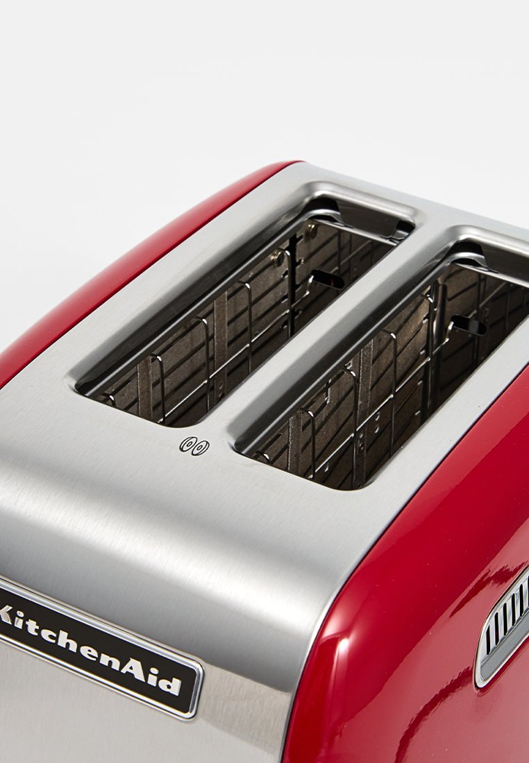 Roter KitchenAid-Toaster mit zwei Schlitzen, Edelstahl-Finish um die Schlitze, sichtbare Heizelemente und ein schwarzes Logo auf der Vorderseite.
