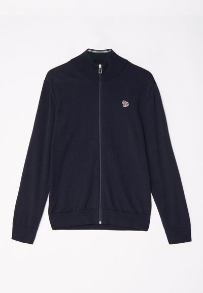 Jūras spēku zipsvārki ar augstu apkakli, garām piedurknēm, ribotām aprocēm un mazu izšūtu dizainu uz krūškurvja. Gluda adījuma tekstūra.