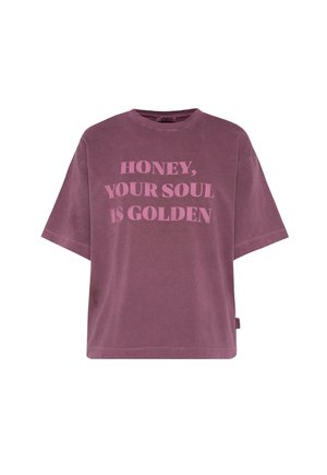 Übergroßes Lavendels T-Shirt aus weichem Baumwollmaterial mit fettem pinkem Text, der "HONEY, YOUR SOUL IS GOLDEN" lautet. Kurze Ärmel und lockere Passform.