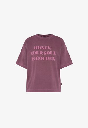 Übergroßes Lavendels T-Shirt aus weichem Baumwollmaterial mit fettem pinkem Text, der "HONEY, YOUR SOUL IS GOLDEN" lautet. Kurze Ärmel und lockere Passform.