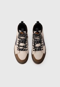 Et par beige høye sneakers med svarte og beige stripete snørebånd, brune gummi tåhetter og svart indre foring, sett ovenfra.