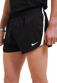 Shorts sportivi neri con una striscia bianca laterale, vita elastica, realizzati in tessuto traspirante, con un piccolo logo Nike sull'orlo.