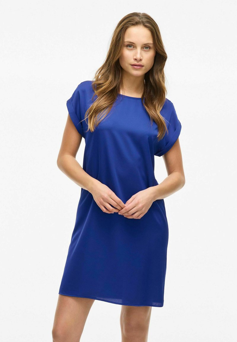 Modrá krátká šatovka s kulatým výstřihem, vyrobená z hladkého materiálu, má volný střih a sahá nad kolena, bez dalších ozdob.
