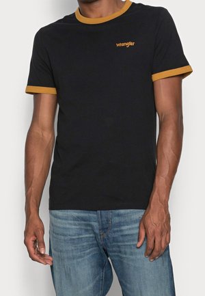 Czarna bawełniana koszulka z musztardowymi ściągaczami wokół kołnierza i rękawów, z małym haftowanym logo "Wrangler" na piersi.