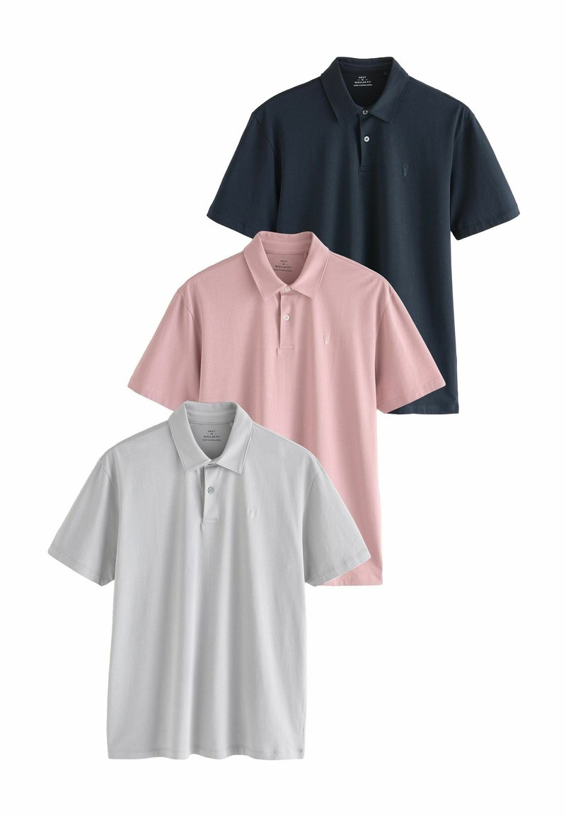 Kolme polojakkua pinoittain: tummansininen, vaaleanpunainen ja vaaleanharmaa. Jokaisessa on kauluspaita ja pieni emblem rinnan kohdalla.