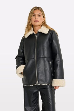 Giacca di pelle nera con colletto e polsini in pelliccia sintetica color crema. Presenta una zip frontale e tasche laterali con zip per la praticità.
