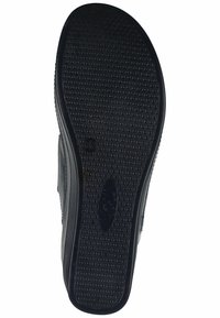 Black rubber shoe sole featuring a textured surface with small, raised dots for grip. Includes branding and size markings on the side.
