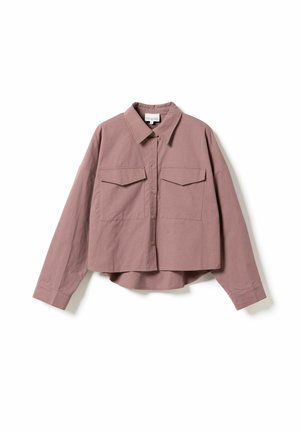 Krustota krekls putekļrozā krāsā, izgatavots no gludas auduma. Tam ir vērsta apkakle, pogu aizdare, divas krūšu kabatas un garas piedurknes ar pogām.