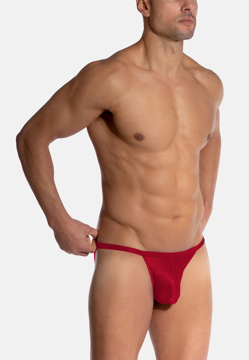 Roter Netz-Männerthong mit tief sitzendem Design und minimaler Bedeckung. Weicher Stoff, schmaler Bund und nahtlose Seiten.