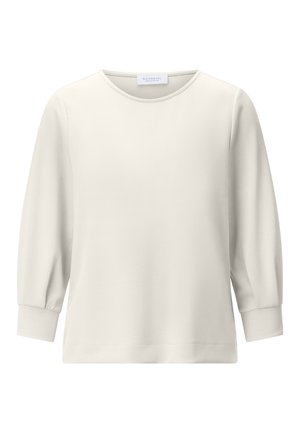Cream-colored long-sleeve shirt with crew neck and fitted cuffs, simple design, displayed on a white background.