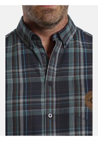 Kurzarm-Hemden aus karierter Baumwolle in Blau- und Grüntönen mit Button-Down-Kragen, einer Brusttasche und einem Logo-Patch.