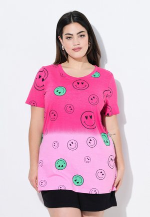 Felle roze T-shirt met een gradient ontwerp, versierd met zwarte smiley-gezicht patronen in groen en zwart. Zachte stof, ronde halslijn, korte mouwen.