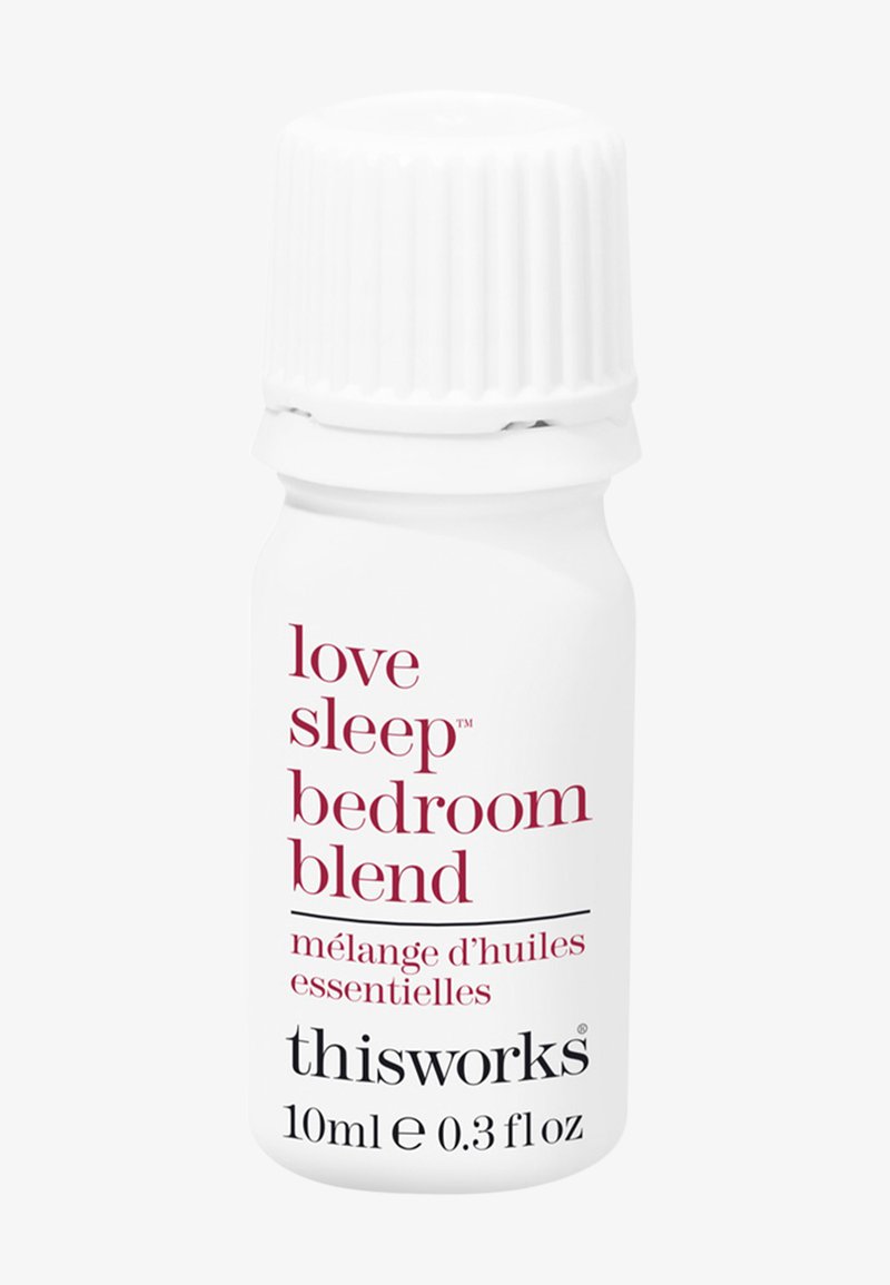 Petite bouteille blanche d'huile essentielle Thisworks Love Sleep Bedroom Blend, 10 ml, avec un bouchon à vis blanc cannelé.