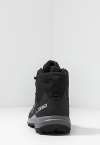 Czarne buty trekkingowe z siateczkową i syntetyczną cholewką, gumową podeszwą i szarymi akcentami. Posiadają pętlę do zakładania oraz usztywniony obcas dla lepszego wsparcia.
