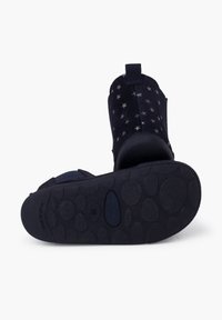 Botas de ante azul marino con patrón de estrellas, suela de goma plana y tirador en la parte trasera. Diseño flexible con agarre texturizado en la suela.
