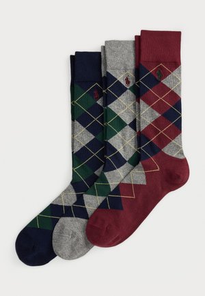 Tre paia di calze a rombi nei colori verde navy, grigio e bordeaux con loghi di cavallo ricamati, disposti fianco a fianco.