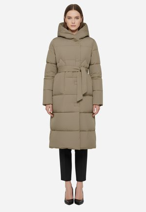 Piumino color marrone chiaro con cappuccio, vita stretta da una cintura e design trapuntato. Maniche lunghe e lunghezza fino al ginocchio, abbinato a pantaloni neri e tacchi.