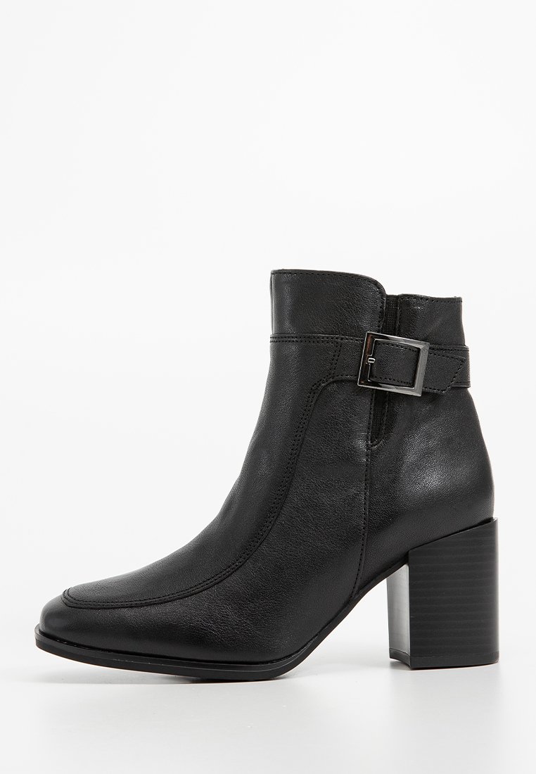 Bottine en cuir noir avec un bout carré, détail de boucle latérale et un talon carré épais. Texture lisse avec des accents de couture subtils.