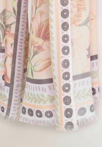 Lillemustriga kangas, millel on roosad liiliad, rohelised lehed ja geomeetrilised servad lavendli, koore ja heleoranži värvitoonides, narmendavate äärtega.