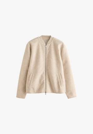 Beige zip-up jakke lavet af blødt stof, med en rund krave, to forlommer og en glat, utextureret overflade.