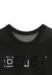 Zwarte t-shirt met ronde hals en gaasdetails op de schouders, voorzien van een glanzend zwart "DKNY" logo gecentreerd op de borst.